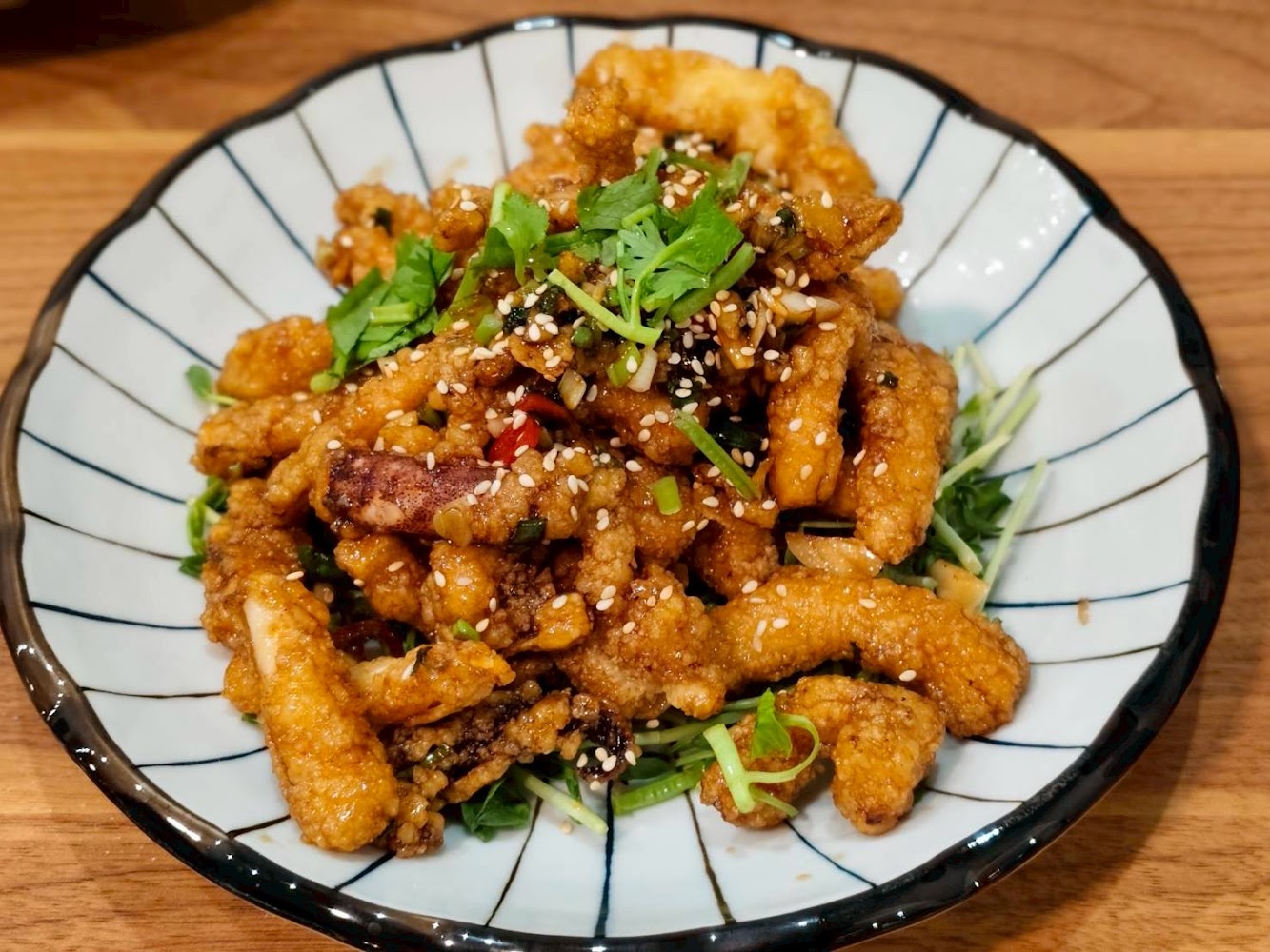 炸魷魚料理撒上芝麻與蔥花的近拍