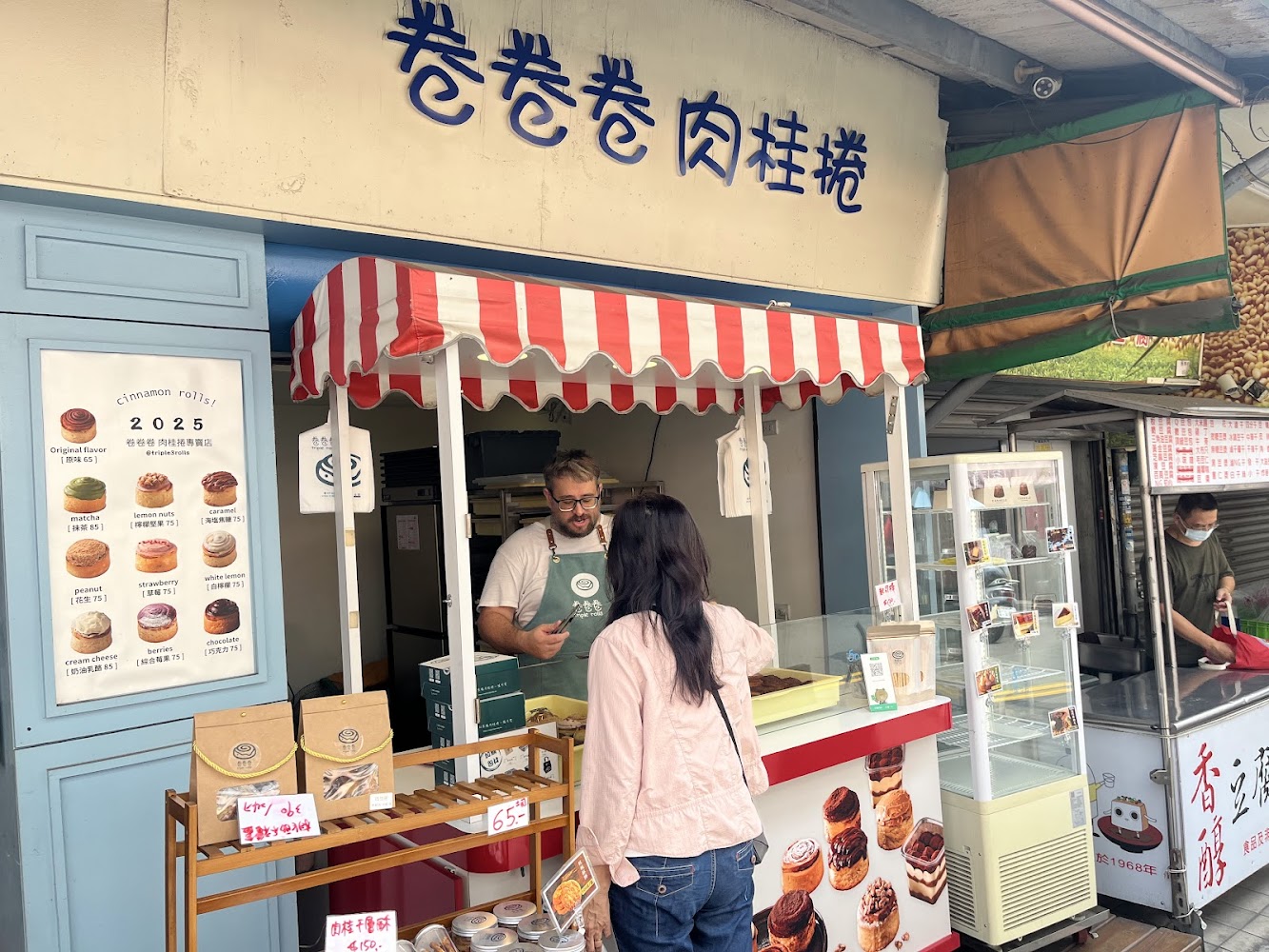 卷卷卷第五市場攤位門面,店招明顯並展示多種口味肉桂捲