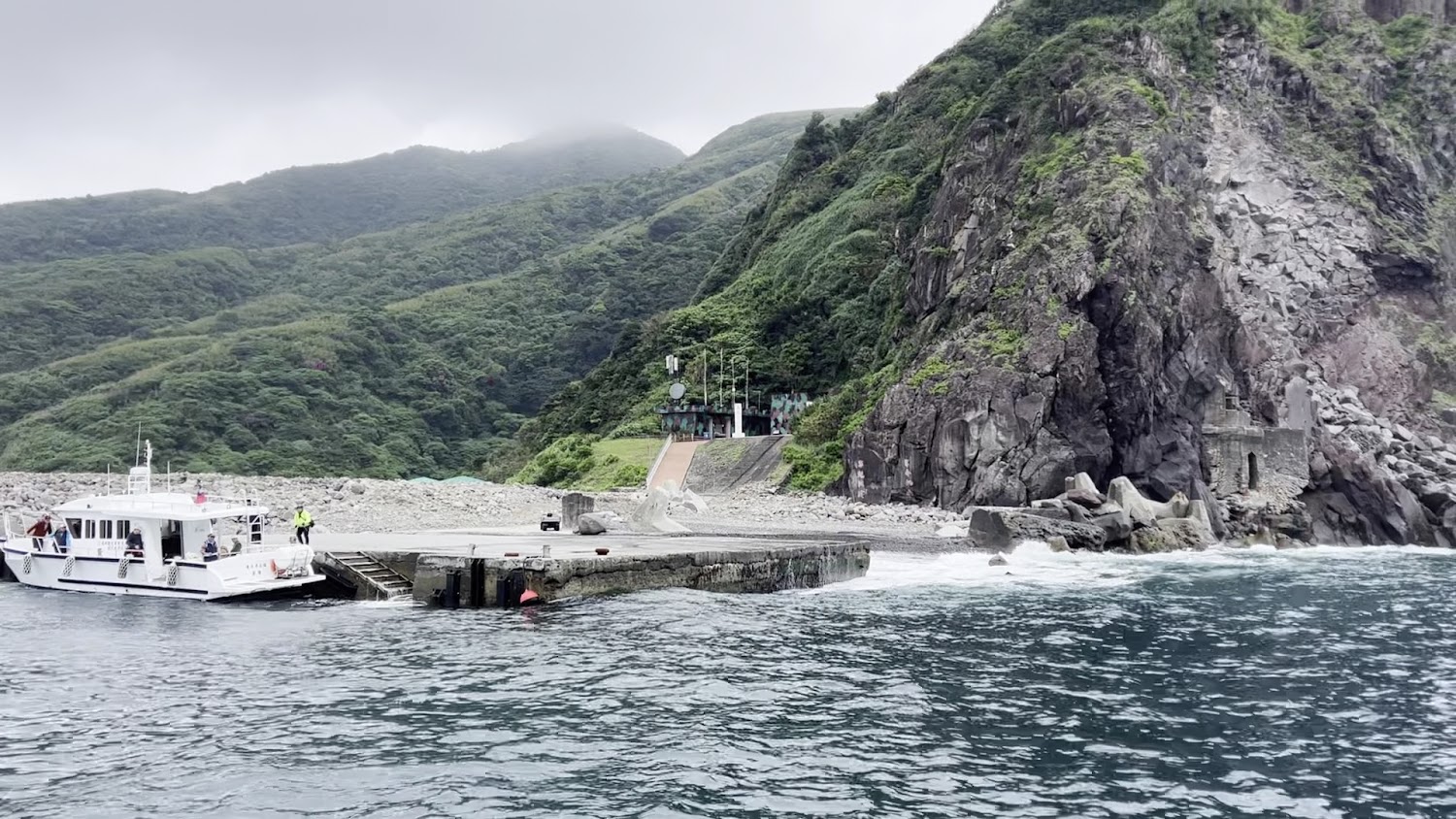 龜山島南岸碼頭停靠白色船隻與山海景色