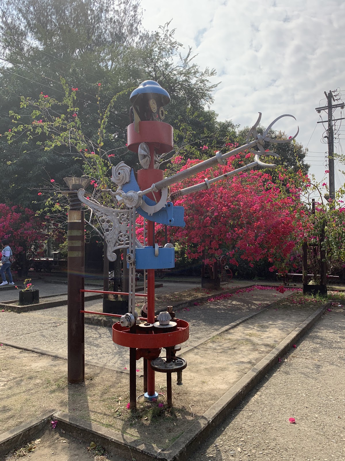 鐵園迷城廢鐵機器人雕塑，舊鐵軌，九重葛粉紅花海背景