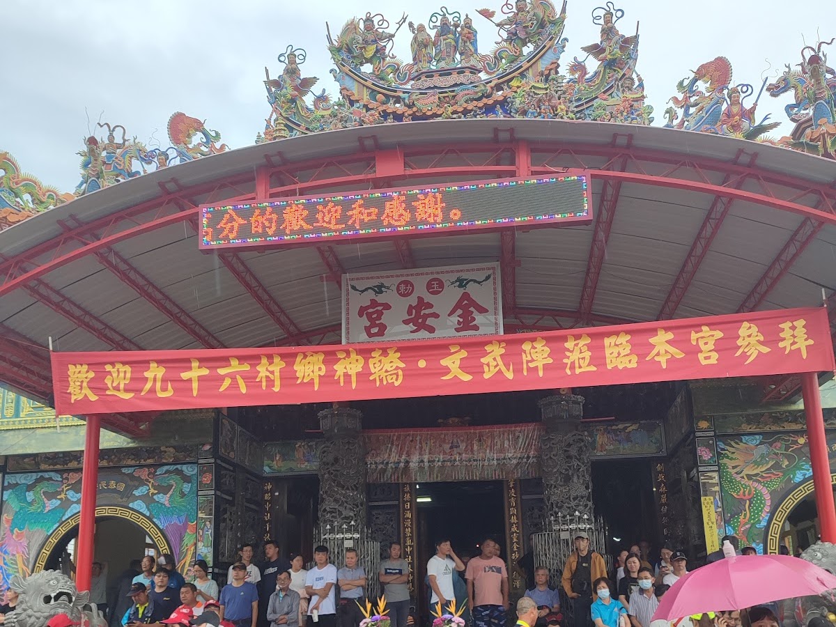 西港慶安宮刈香,廟前懸掛歡迎九十六村鄉神駕橫幅,信眾撐傘參觀