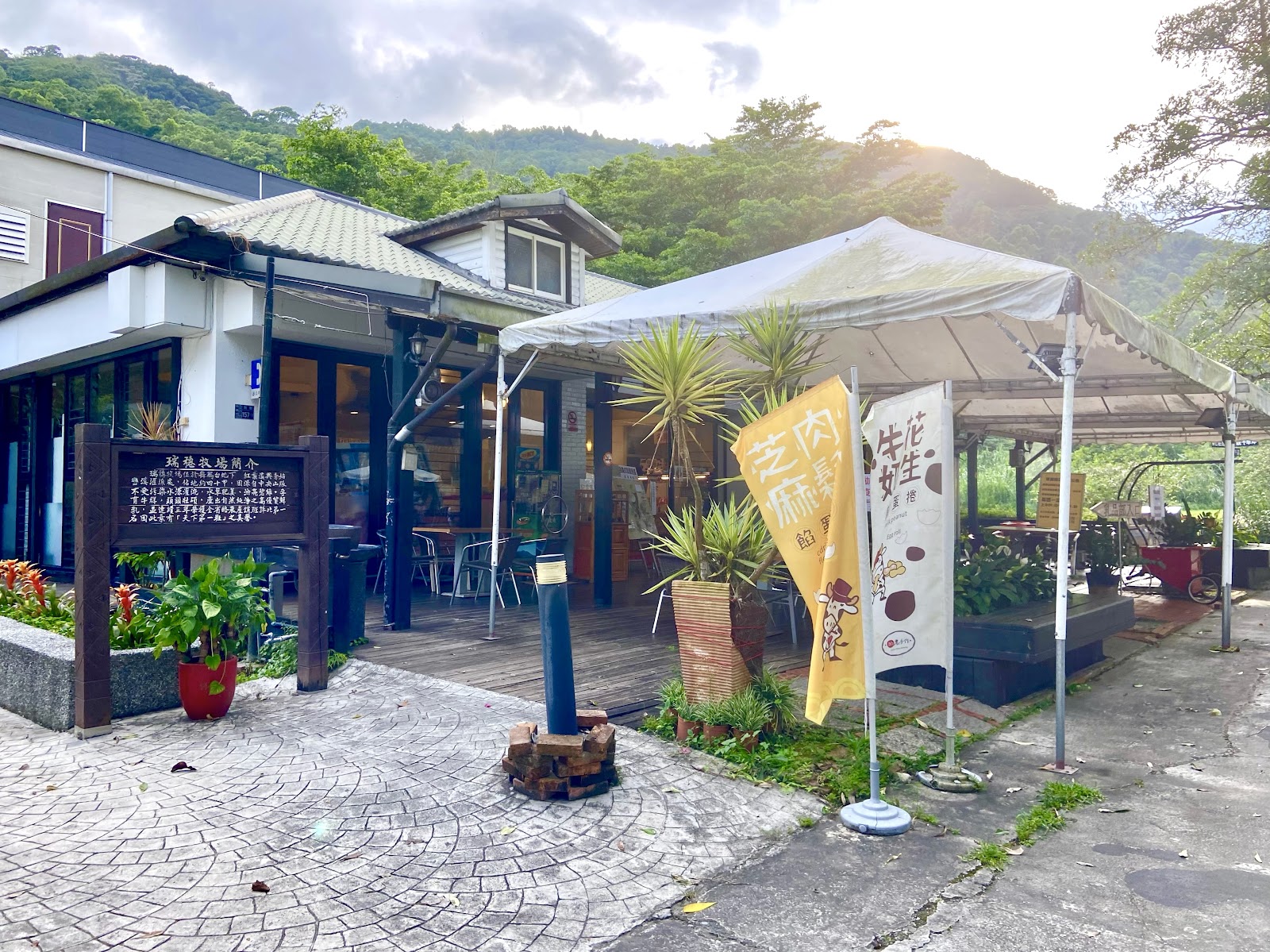 瑞穗牧場入口區，簡介看板與戶外攤位，山景夕陽
