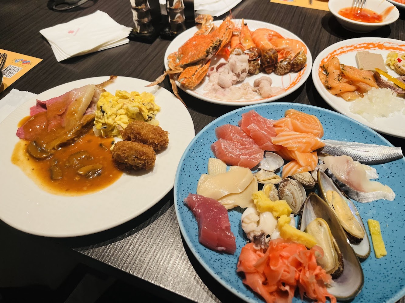 台中廣三SOGO店餐桌上有生魚片海鮮烤肉炸物與冷盤