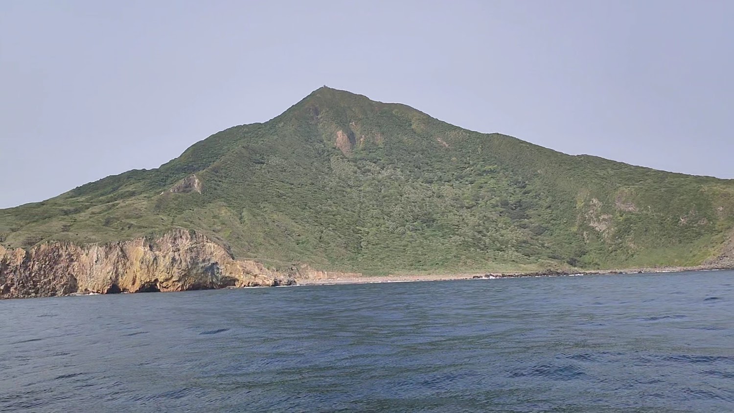 龜山島覆蓋綠色植被的海岸山丘