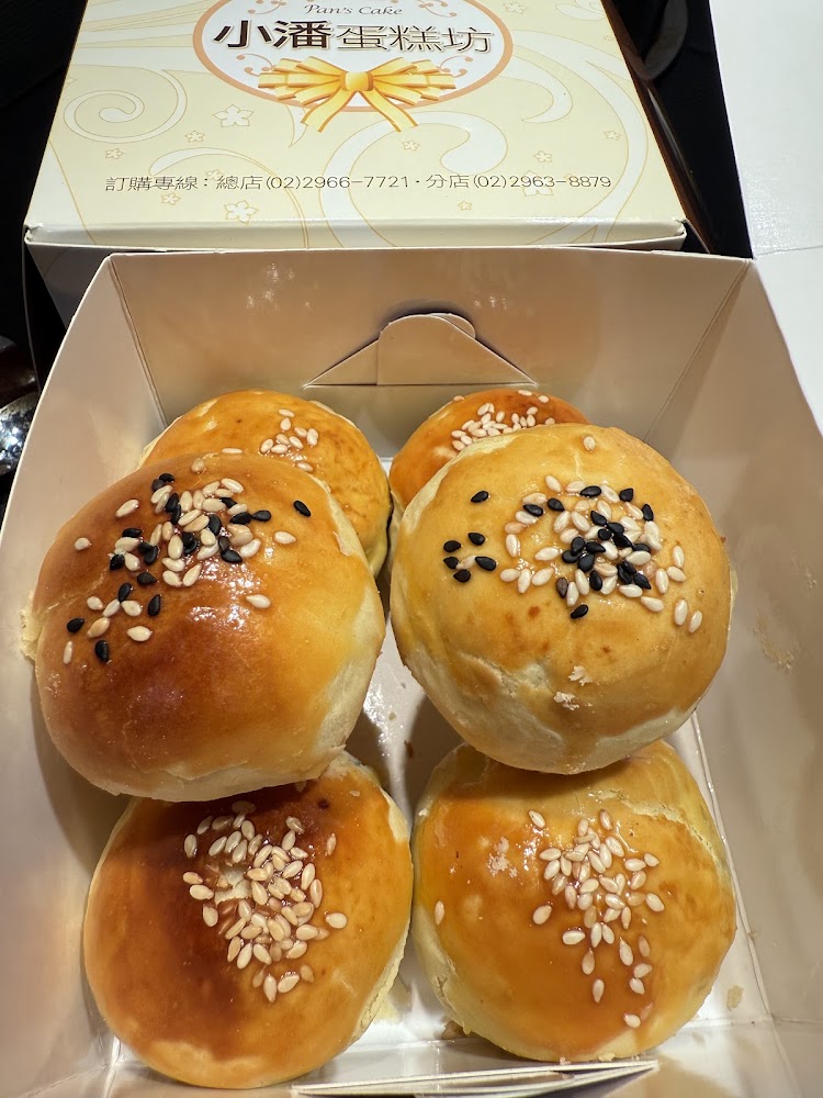小潘蛋糕坊盒裝酥皮麵包，表面撒有黑白芝麻，外皮金黃