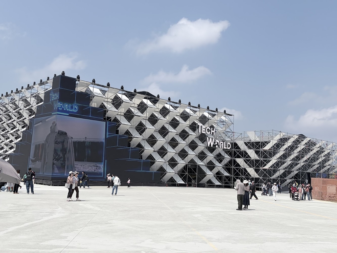 現代感十足的TECH WORLD館外觀，建築外牆具有幾何造型，現場聚集許多遊客。
