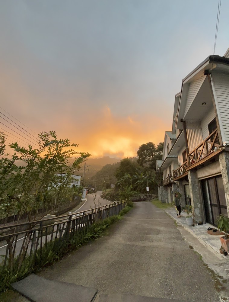 彎曲山路與橘黃色夕陽雲彩的山林景色