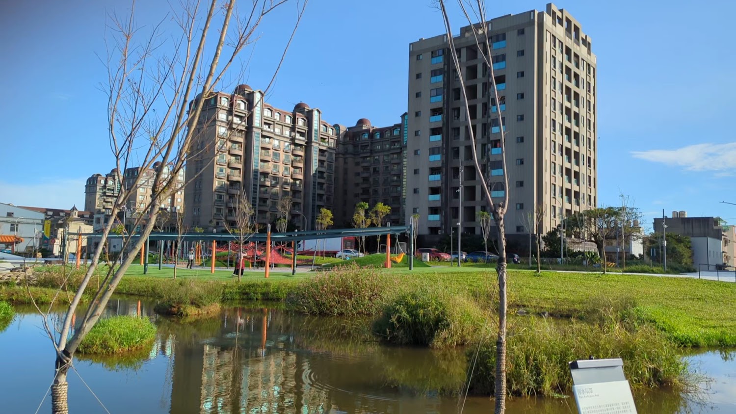 大片綠地水池與高樓住宅背景