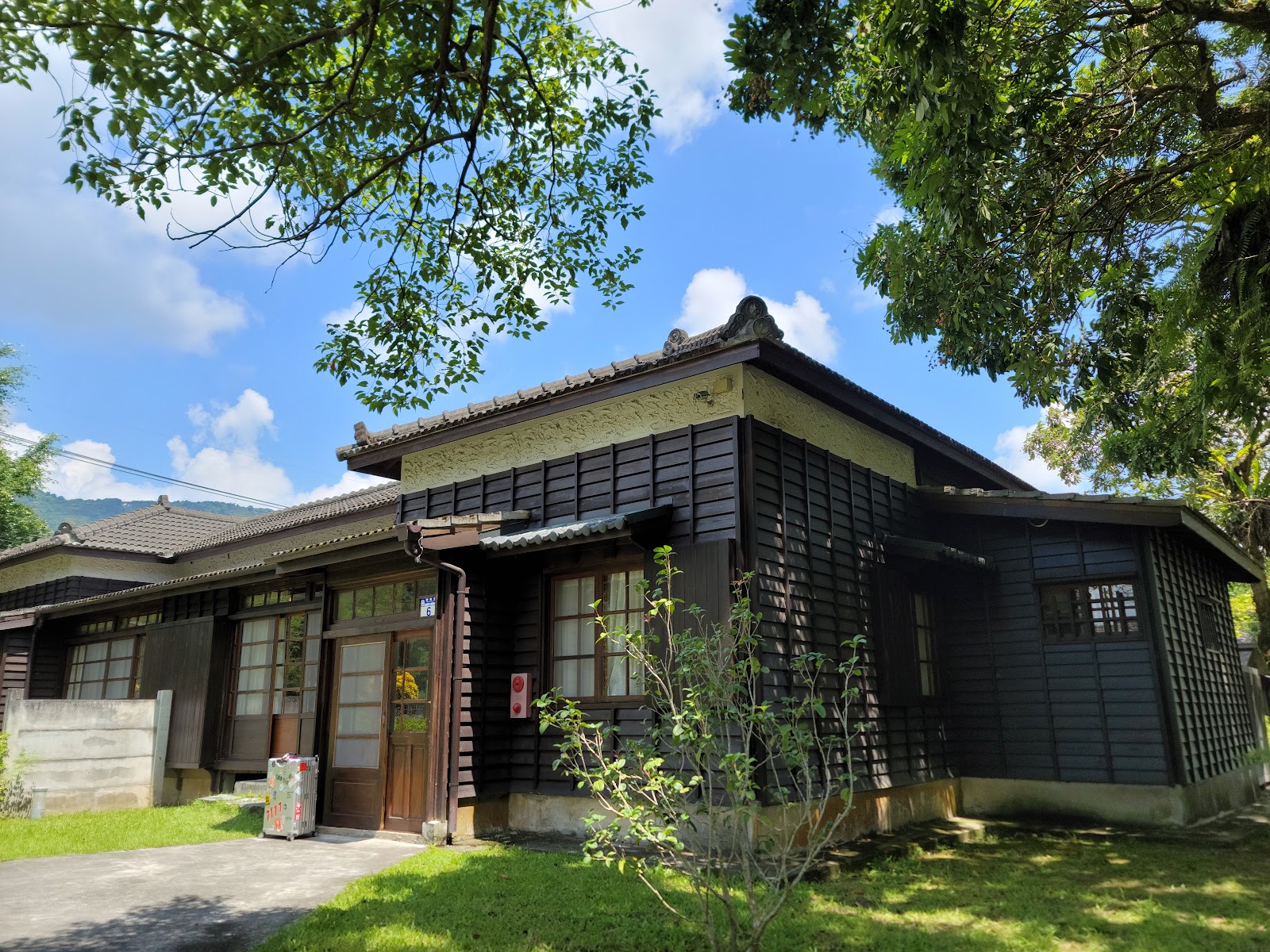 花蓮觀光糖廠日式黑色木造宿舍建築，藍天白雲背景