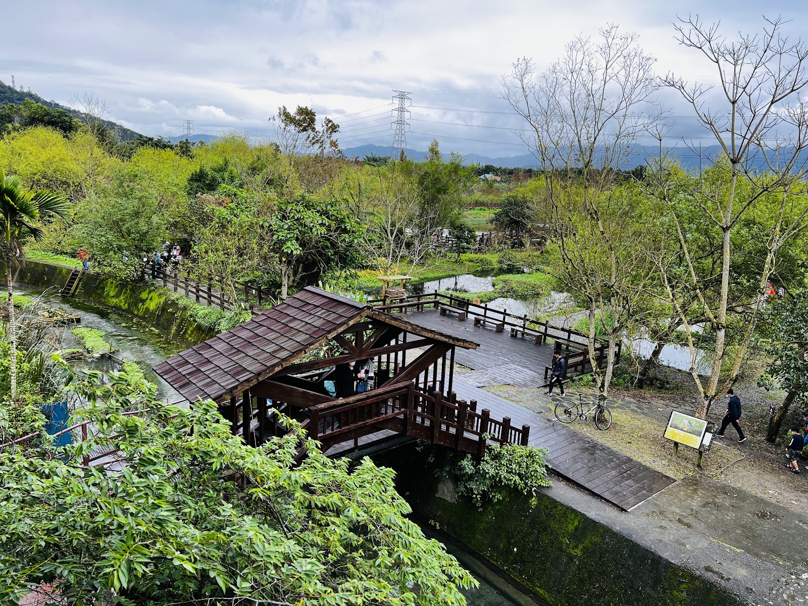 馬太鞍濕地高角度俯視全景，木棧道涼亭與茂密濕地植被，遠山背景