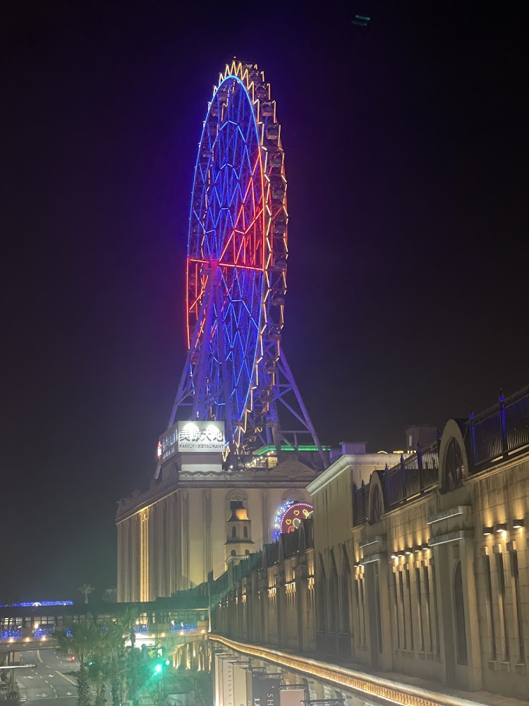 夜色中發光的義大摩天輪與建築