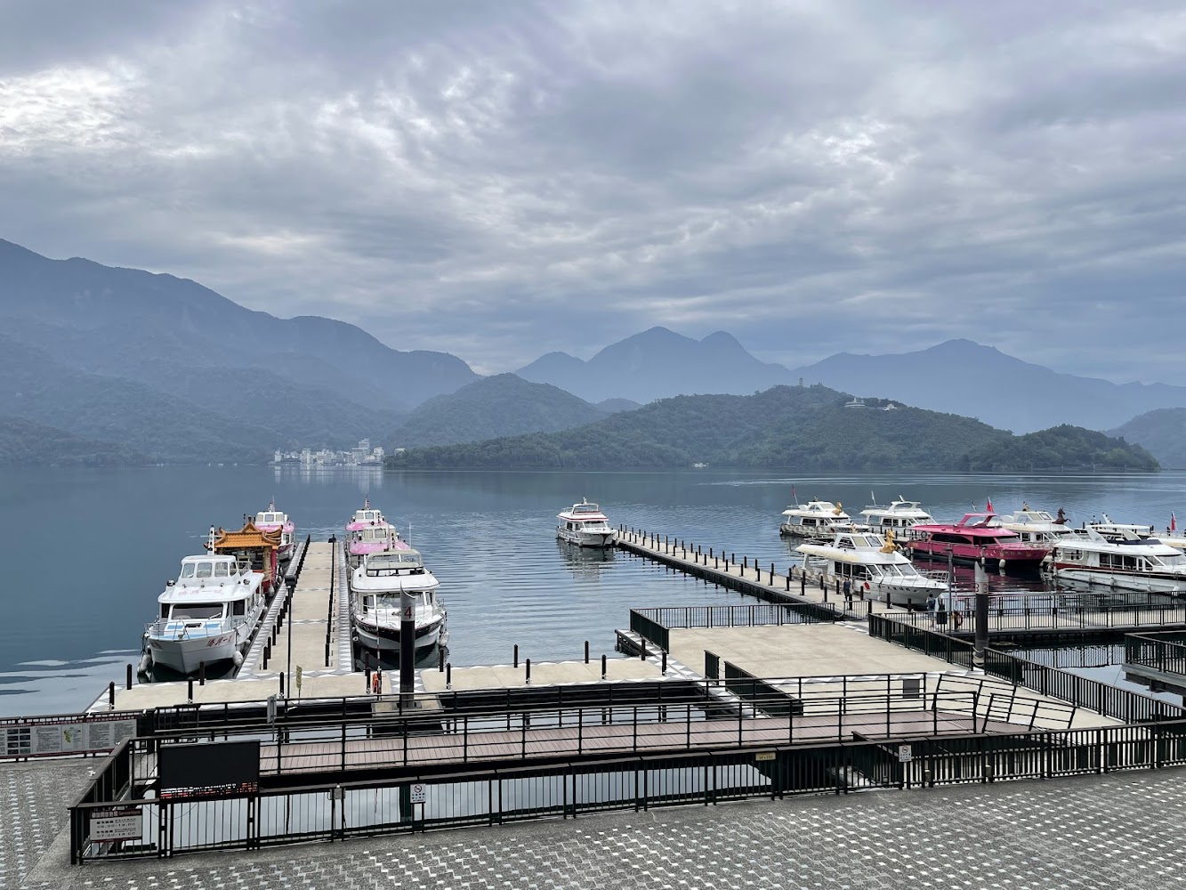 日月潭水社碼頭停靠多艘遊艇與湖山景色