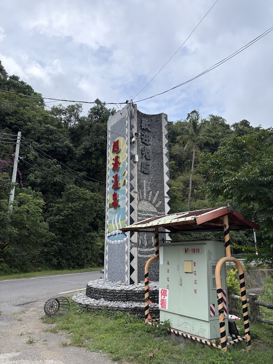 旭海溫泉區入口牌樓立柱飾有排灣族彩色雕刻旁有服務亭