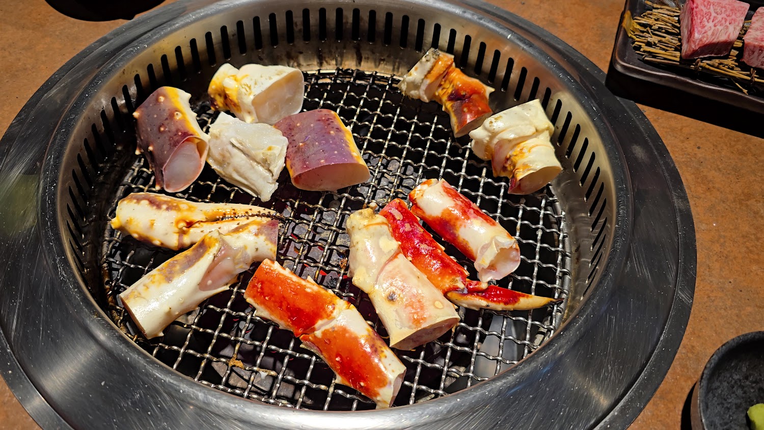 吃肉肉燒肉專門店中壢店烤爐上的帝王蟹腳與牛肉