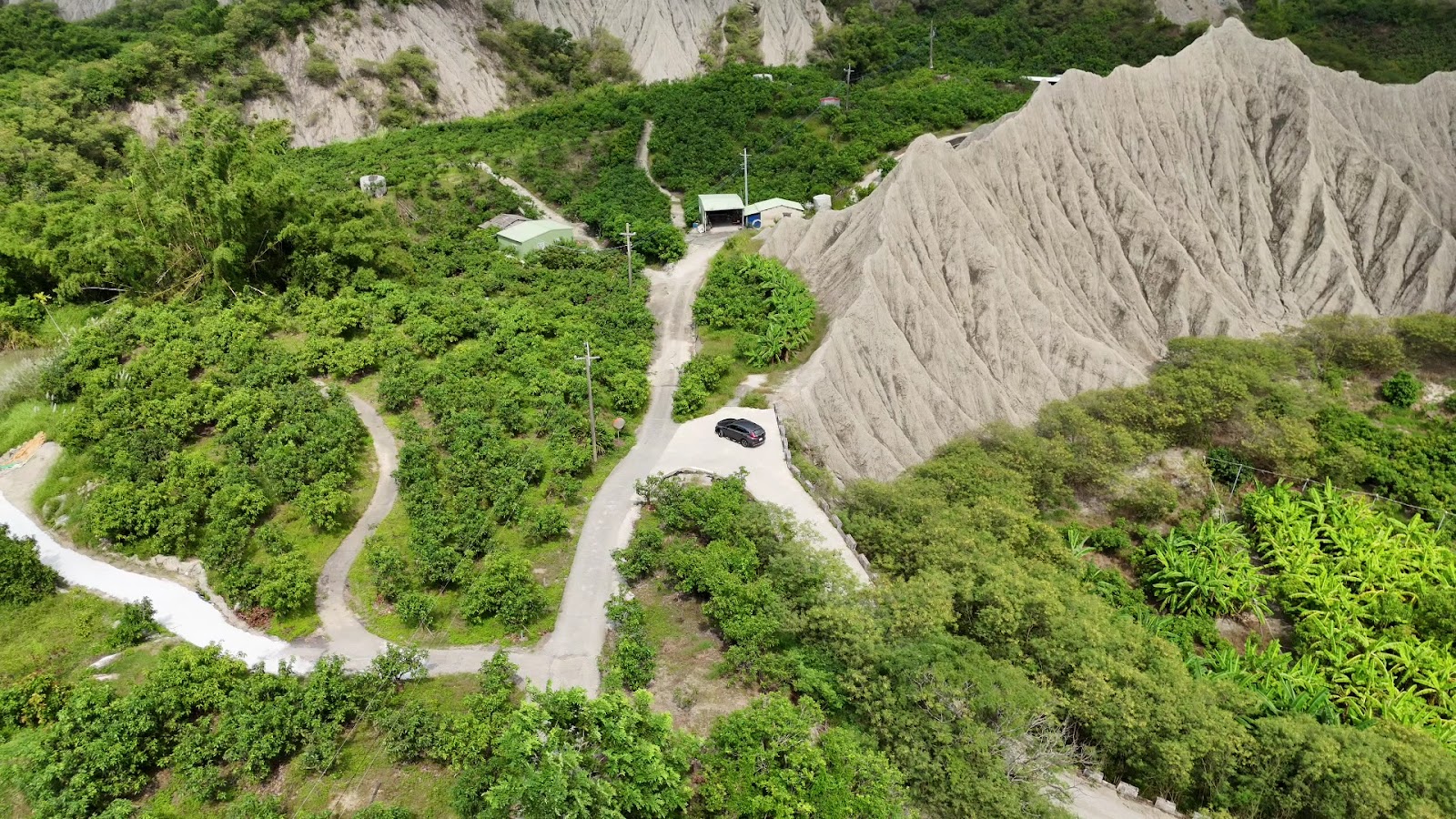 彩疊山空拍全景,蜿蜒山路與泥岩壁