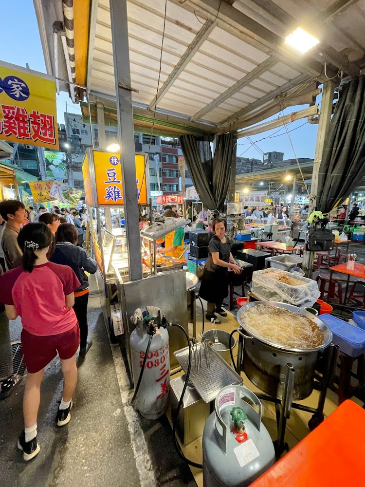 善化夜市豆雞攤位前排隊人潮與大型油鍋,夜市氣氛濃厚。