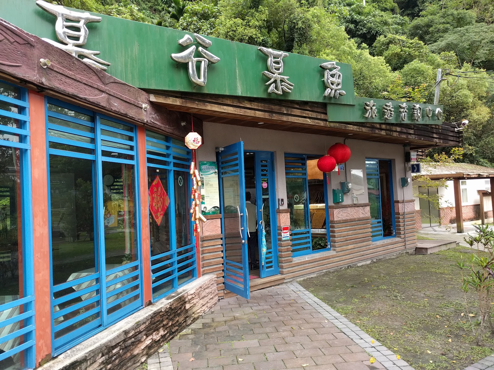 慕谷慕魚旅遊諮詢中心外觀，綠色招牌與藍色百葉窗格