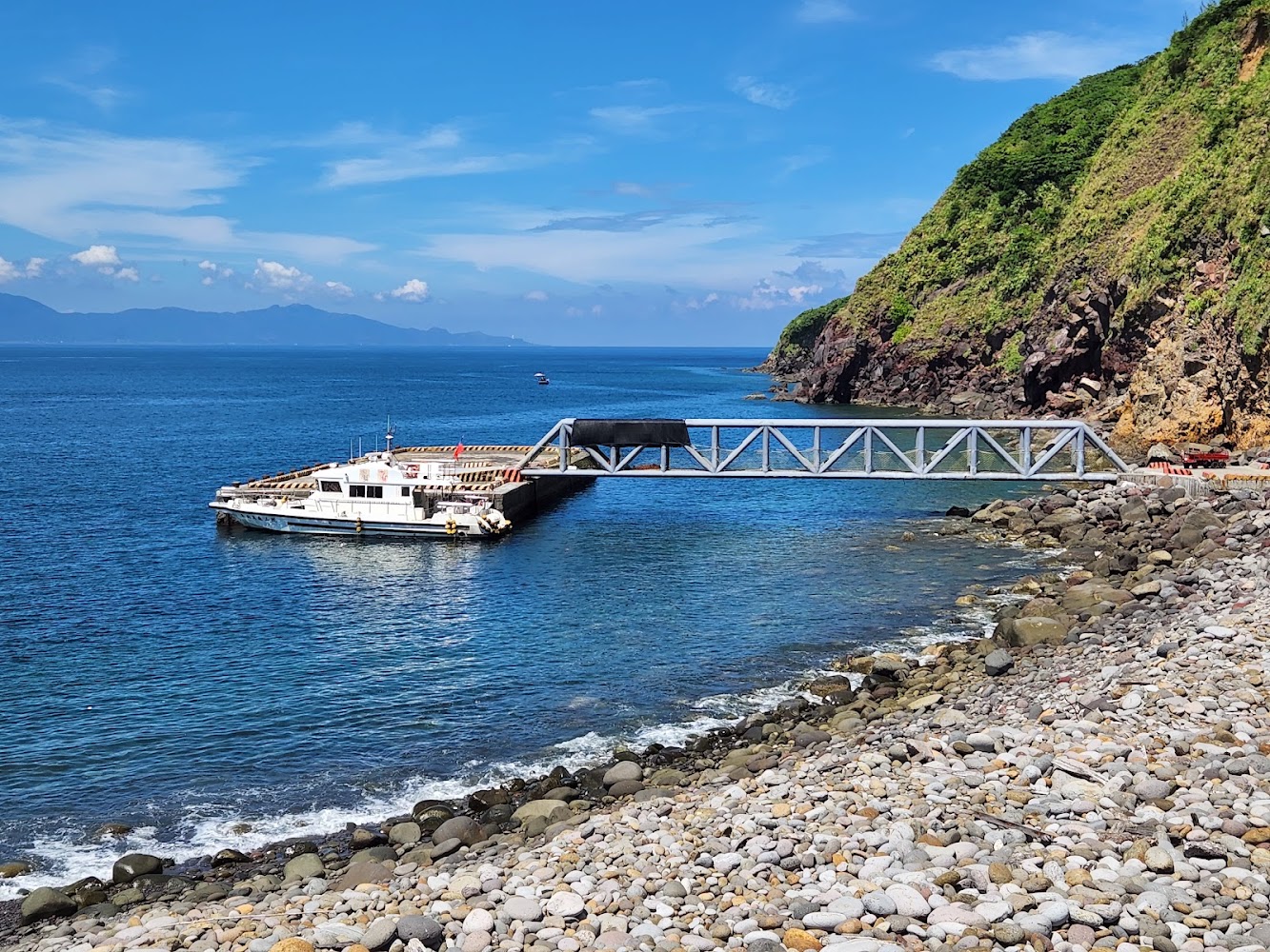 龜山島北岸碼頭停靠小船與山海景色