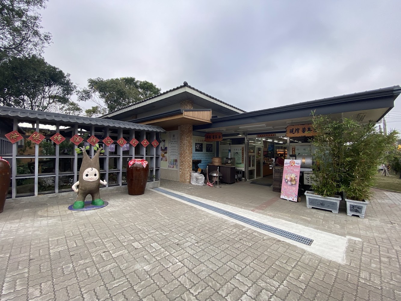 傳統風格商店門面,有大陶甕與可愛吉祥物裝飾