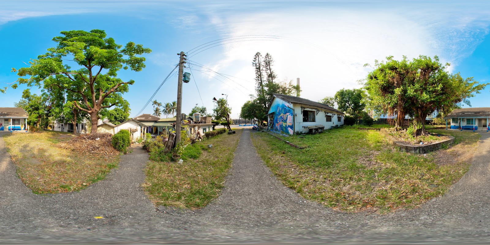 都蘭糖廠廣角全景,老建築兩側綠蔭夾道,右側老白牆有鮮豔彩繪壁畫