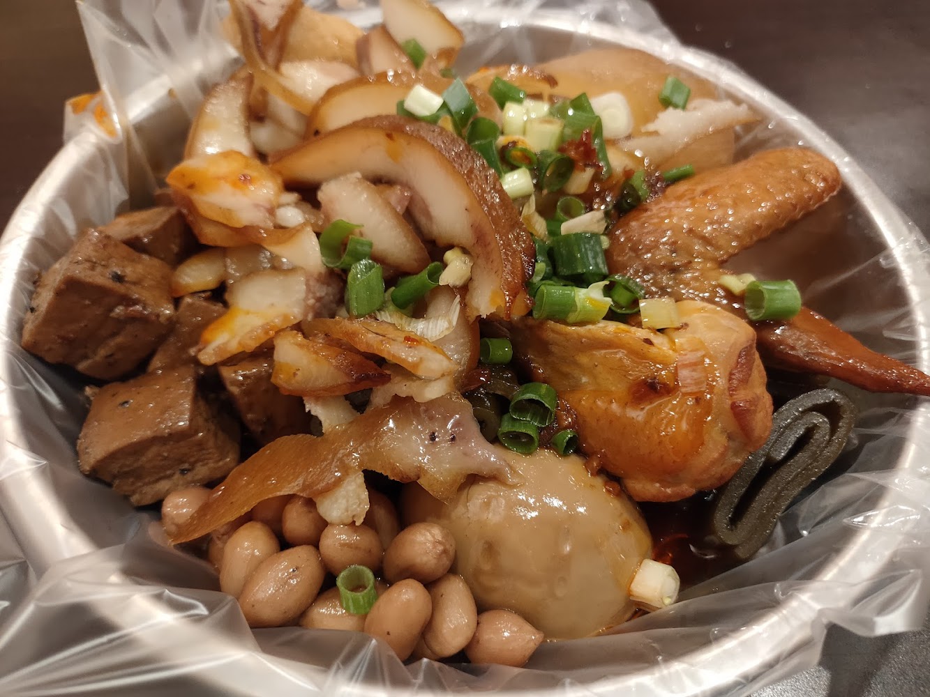 萃年華滷味拼盤,有滷蛋、雞翅、豆乾、花生與豬耳朵等配料