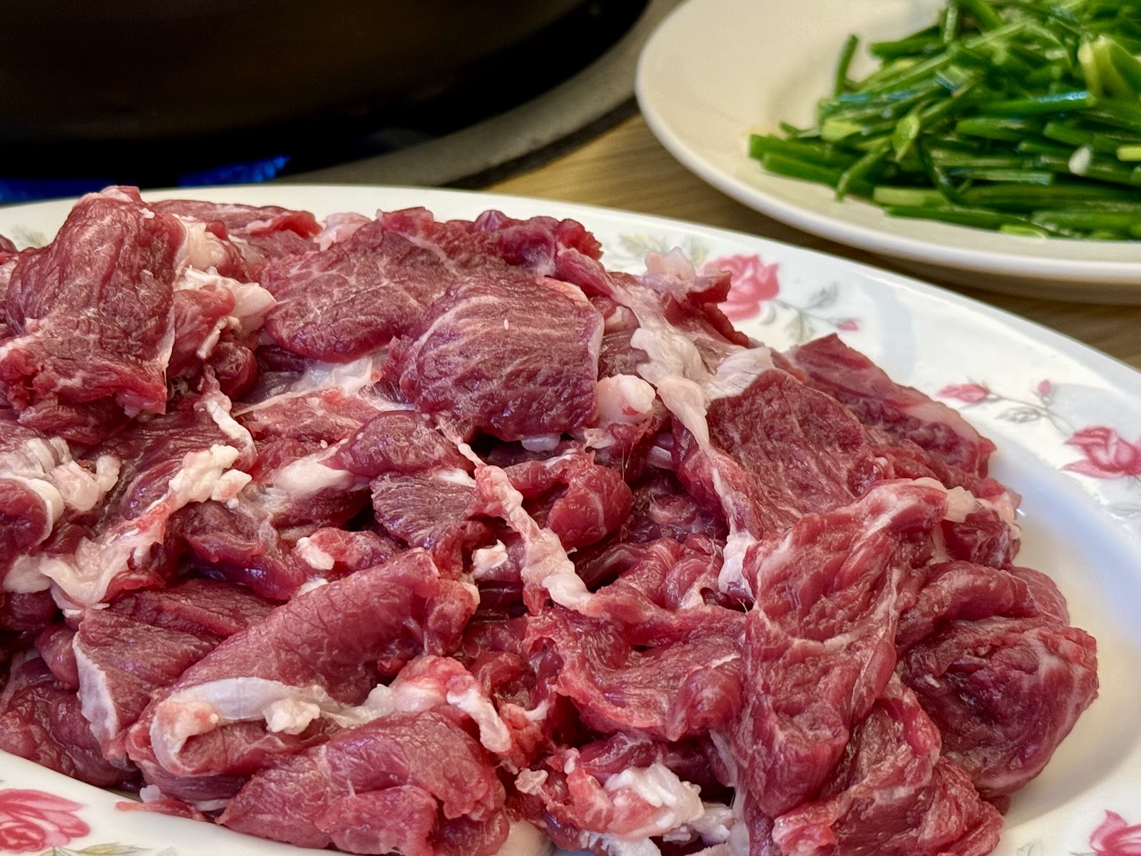 溪湖阿秀羊肉爐新鮮生羊肉大份量盛盤,旁邊配一碟青蔥