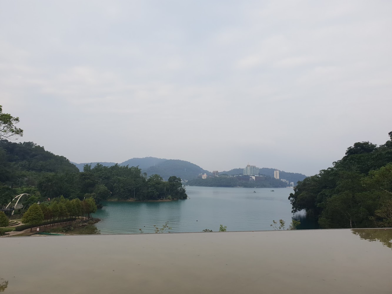 平靜湖面與遠方山丘樹林