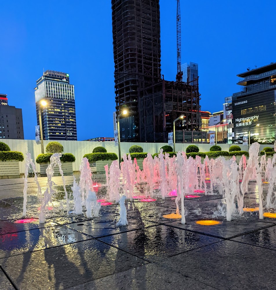 臺北101水舞廣場夜間彩色噴泉與城市高樓景色