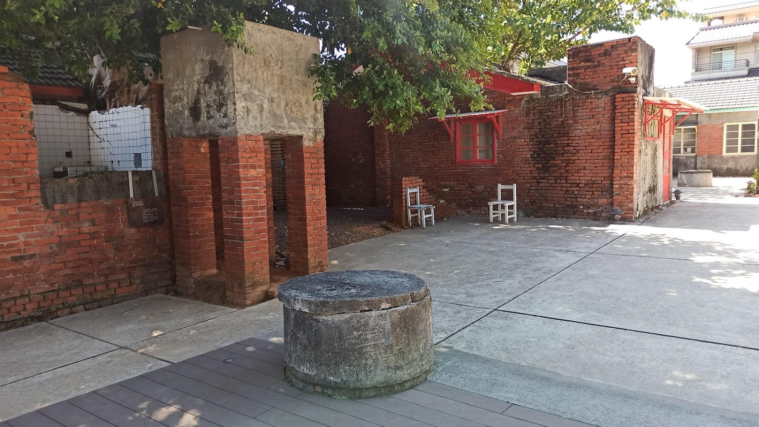 紅磚老建築院子中的古井與白色座椅