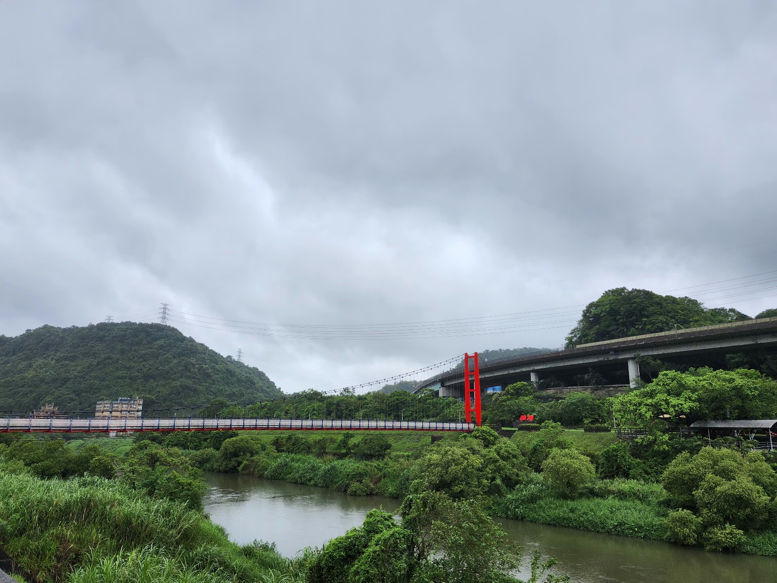 碇內吊橋紅色橋墩壯觀近拍，陰天下的基隆河壯闊景致