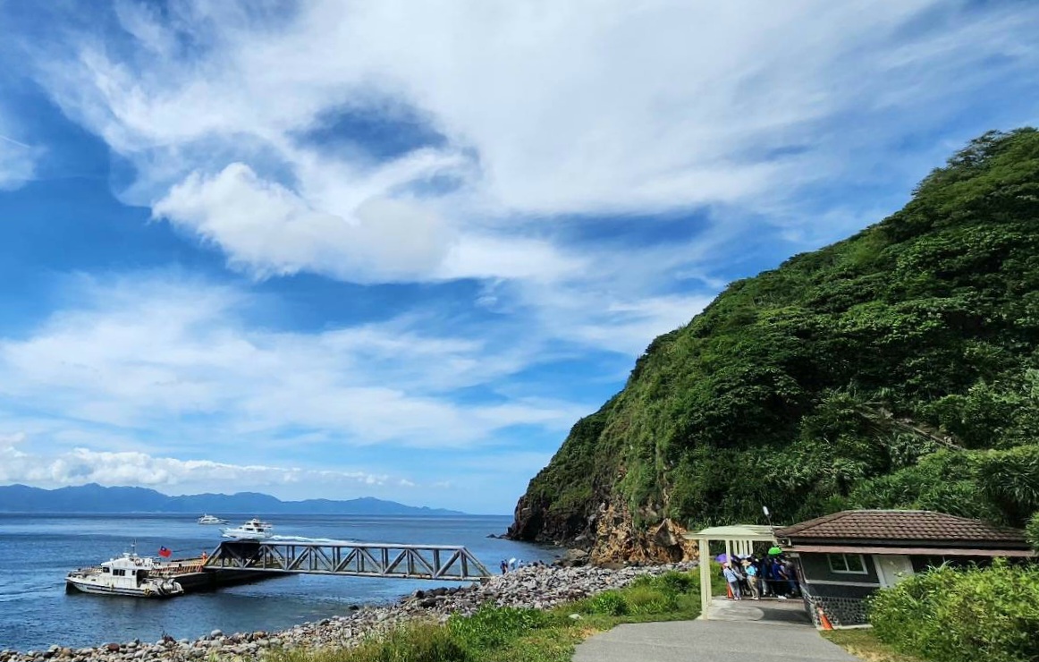 臨海碼頭船隻與排隊遊客風景