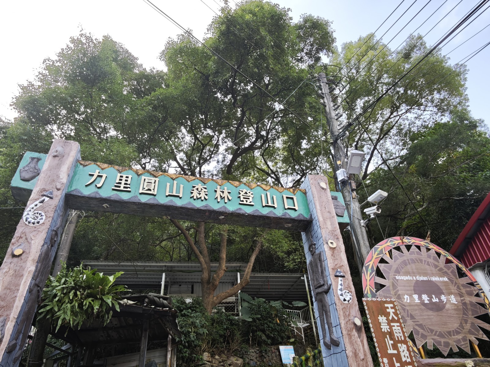 力里圓山森林登山口拱形大門,掛有綠色招牌,排灣族圖騰裝飾,屏東春日鄉