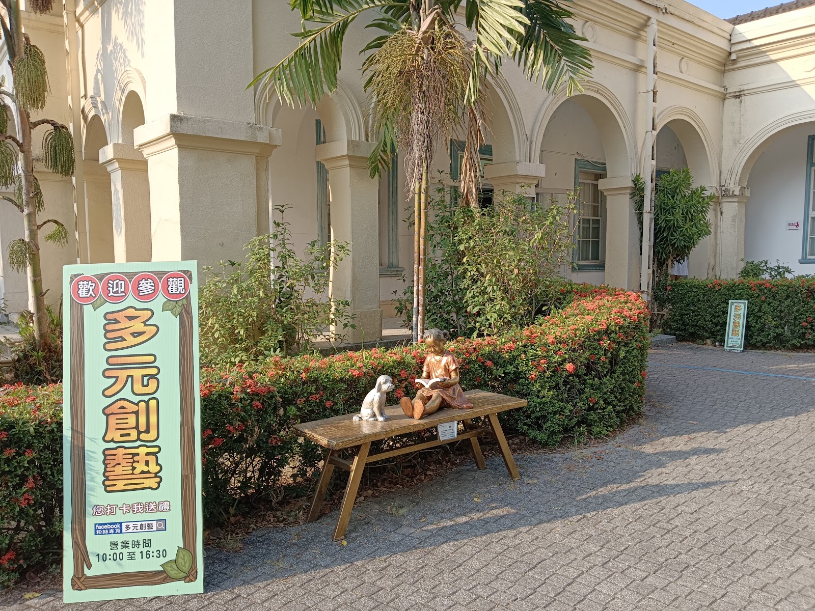 橋頭糖廠多元創藝展區庭院，歡迎參觀招牌，白色拱廊建築
