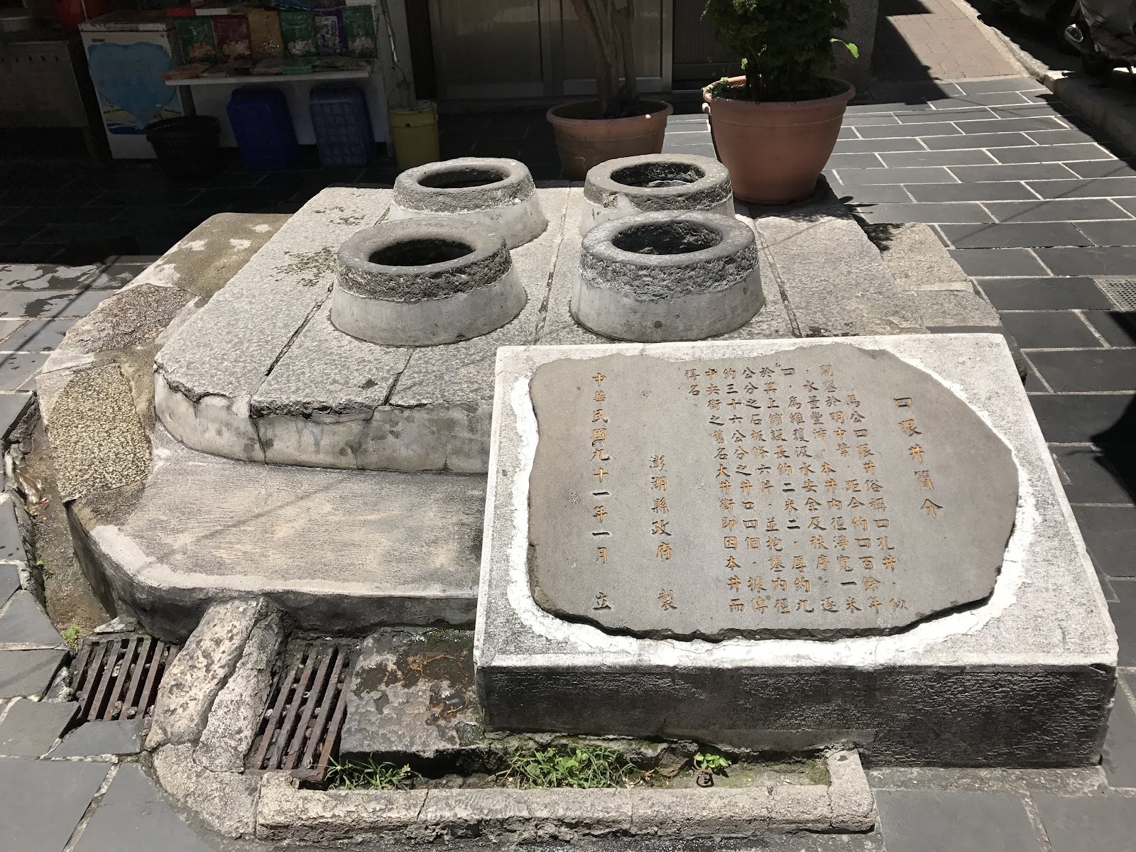 澎湖四眼井，四個圓形石製井口並列石台，旁有歷史石碑