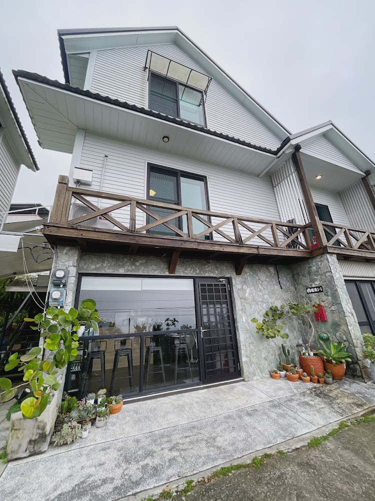 阿里山艾米民宿外觀,灰白色建築搭配木陽台與大片玻璃門窗