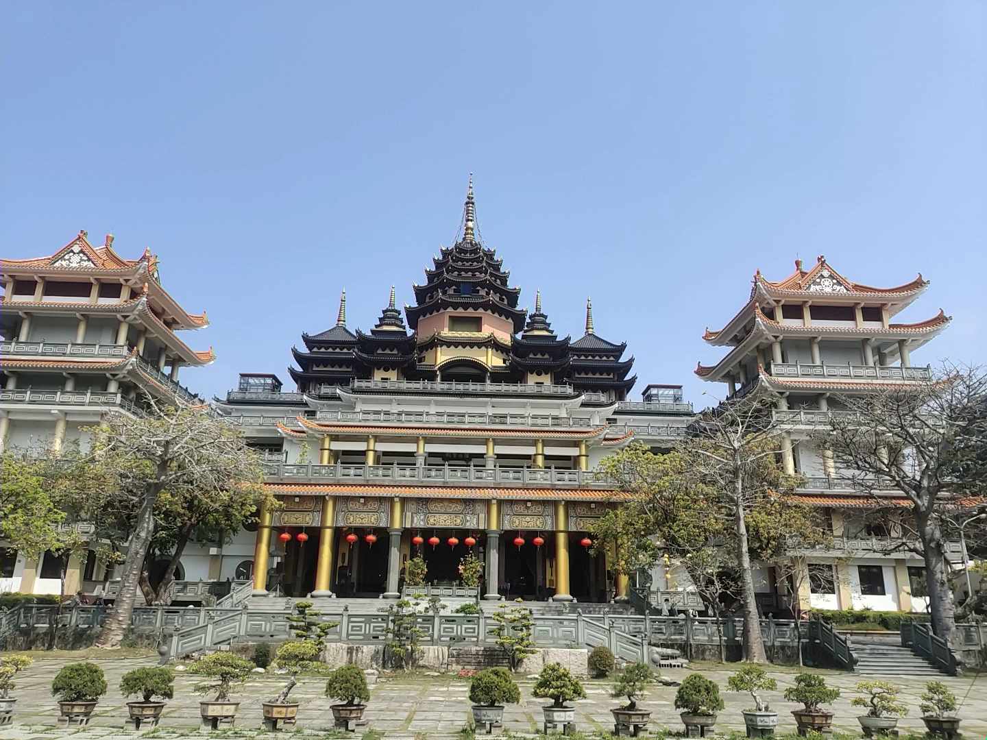 楠西萬佛寺正殿正面全景黑色多層尖塔金色裝飾紅燈籠藍天