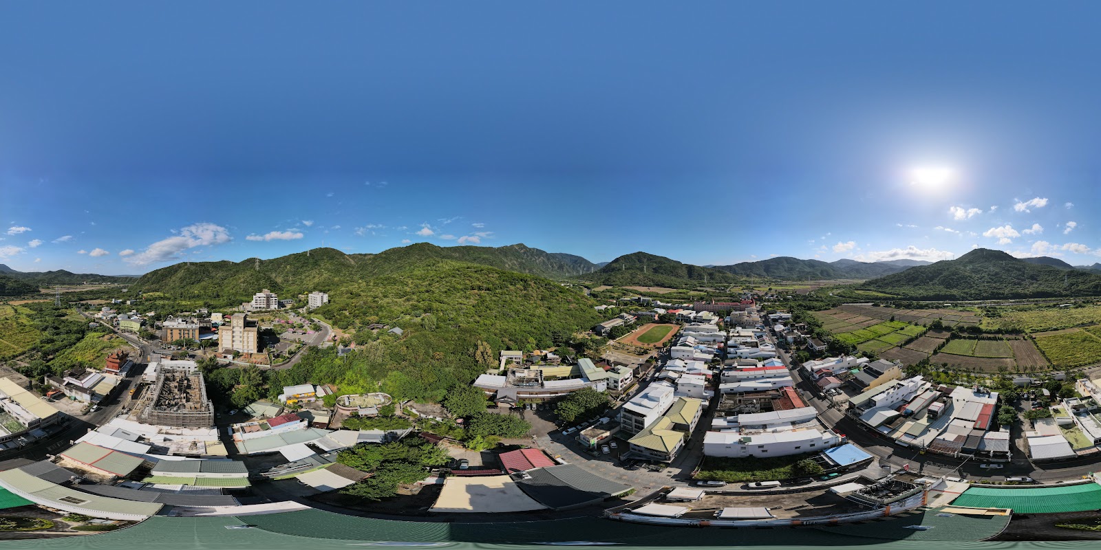 四重溪溫泉小鎮空拍全景，聚落被青山環抱，田野農地連天