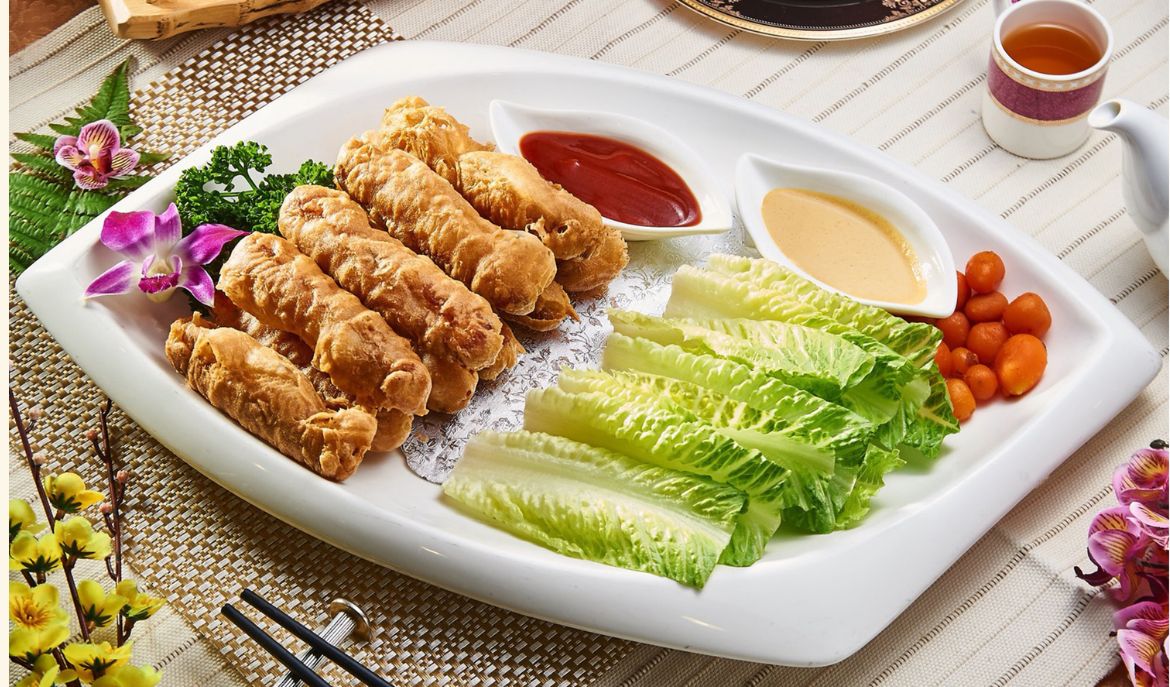 炸卷類中式料理,搭配生菜與醬料,擺盤精美。