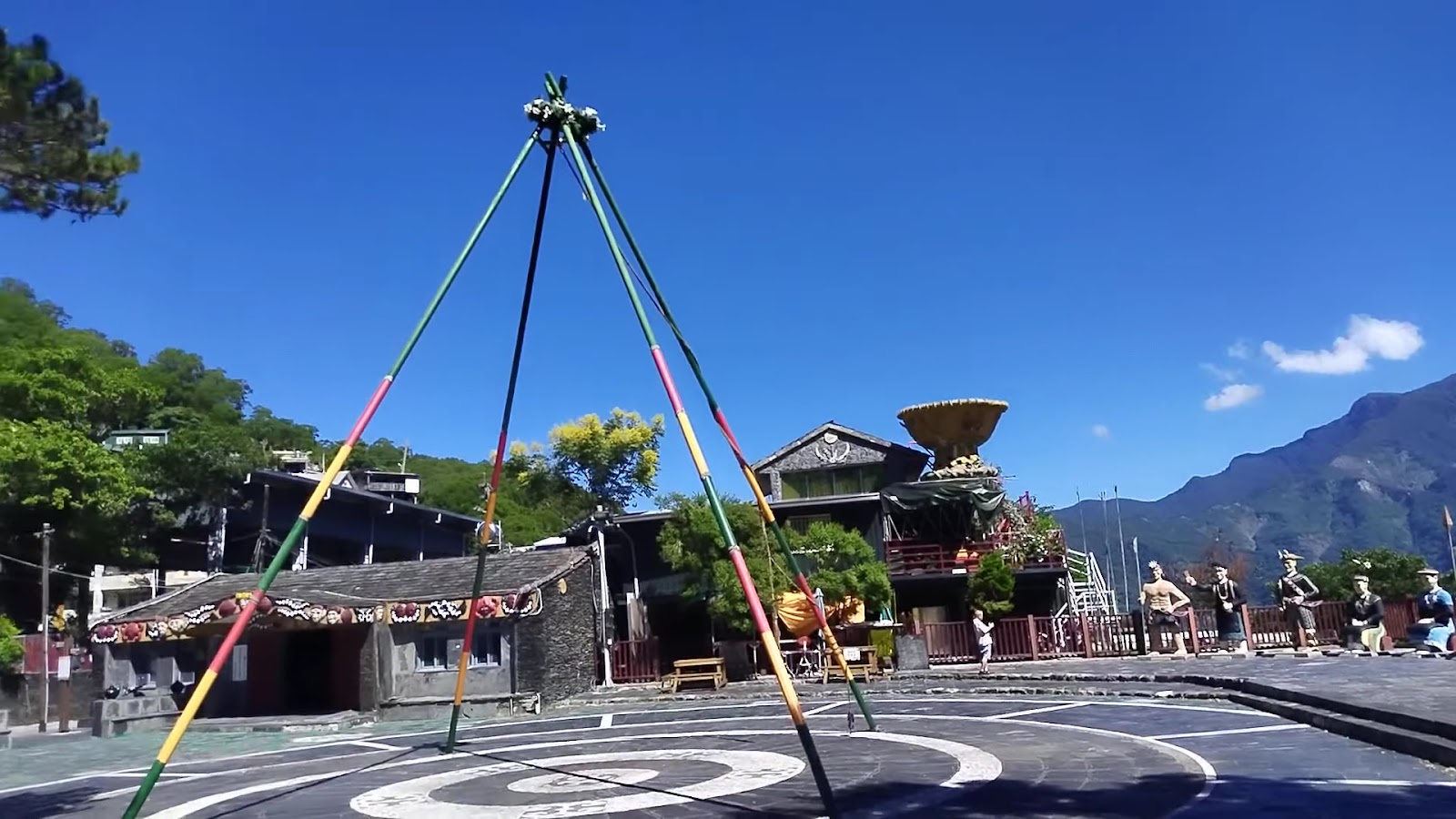 霧台部落廣場彩旗飄揚,藍天白雲下山景盡收眼底