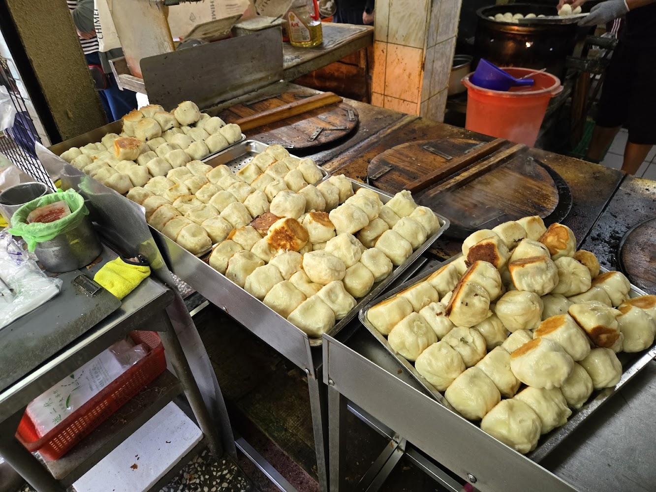 大量剛出爐的生煎包排列整齊在托盤上