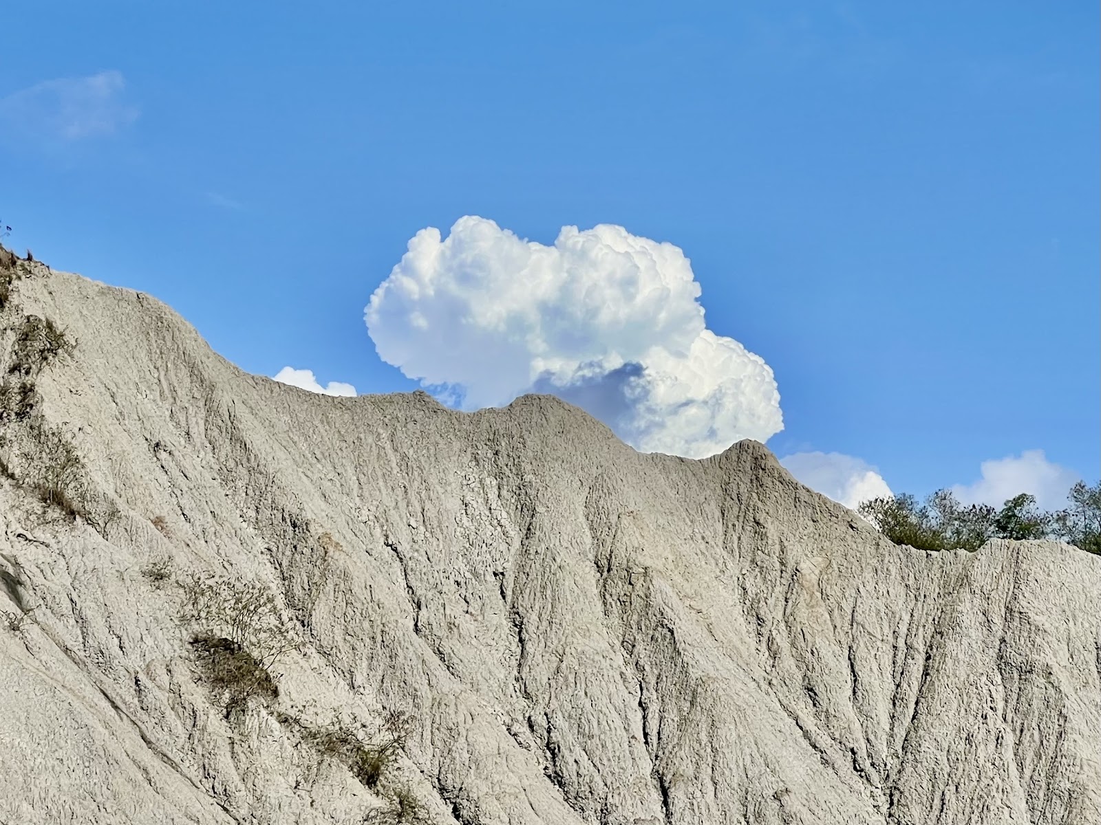 龍崎牛埔惡地灰白泥岩山脊在藍天積雲下顯得格外壯觀,山頂可見遊客身影