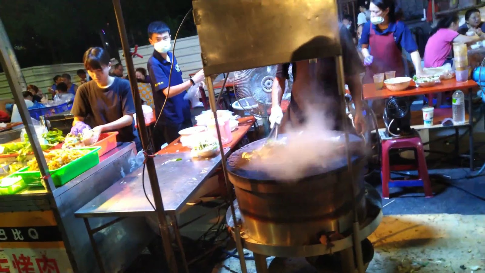 朴子週六夜市料理攤位大型蒸鍋冒出白煙,夜間燈光熱鬧