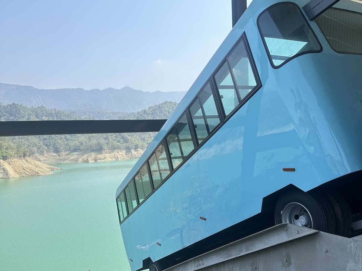 曾文水庫藍色纜車車廂停在軌道上,背後碧綠水庫,嘉義大埔觀景臺