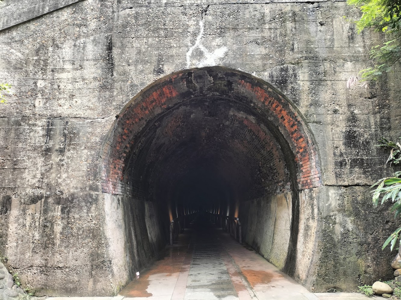 一座用磚石和水泥建造的古老隧道入口，隧道內部昏暗且帶有復古氣息。