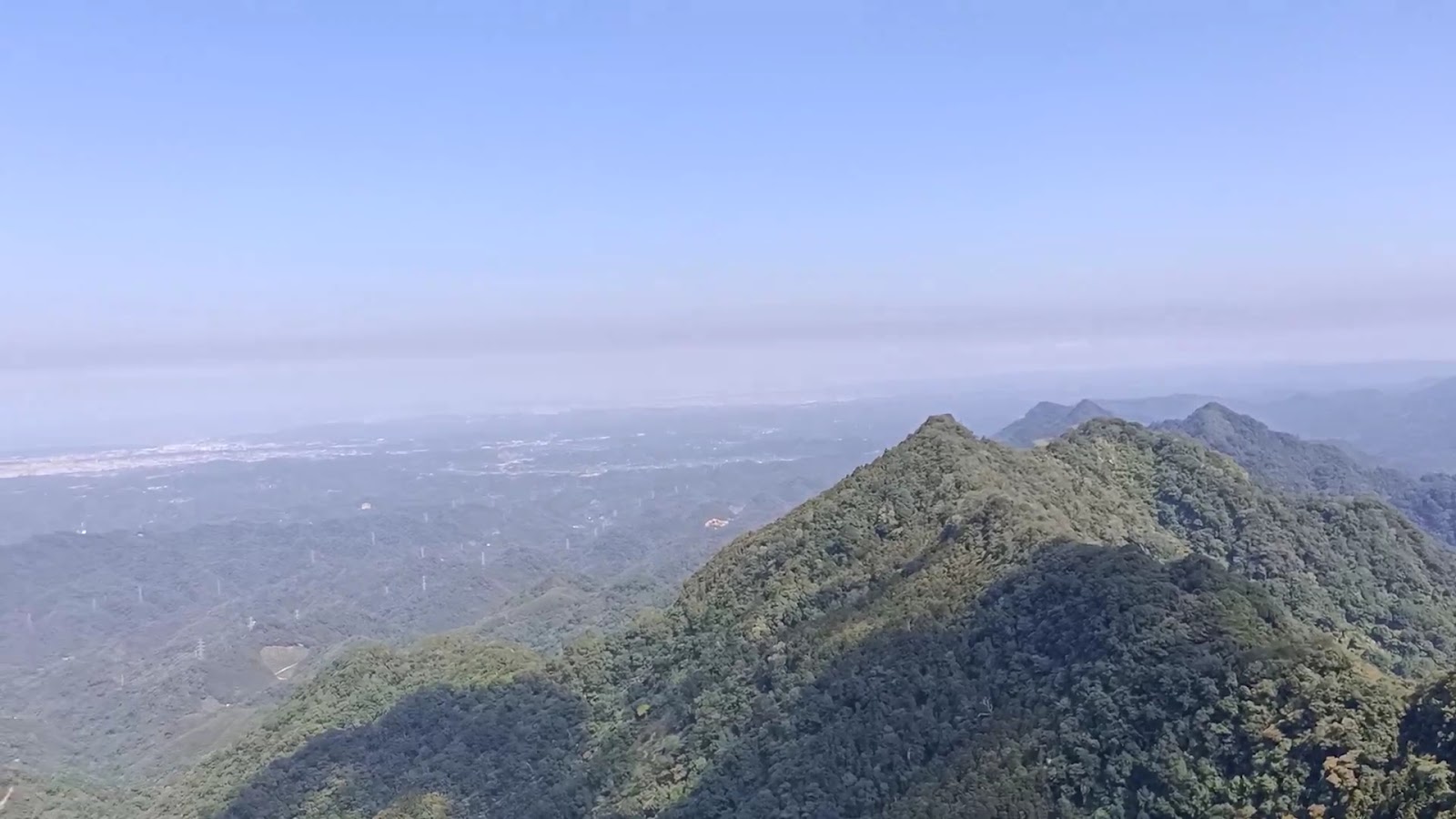 仙山頂峰遠眺，雲霧繚繞山稜，苗栗平原隱現於遠方