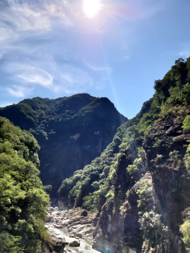 壯麗峽谷與清澈溪流，陽光灑在綠意山谷中