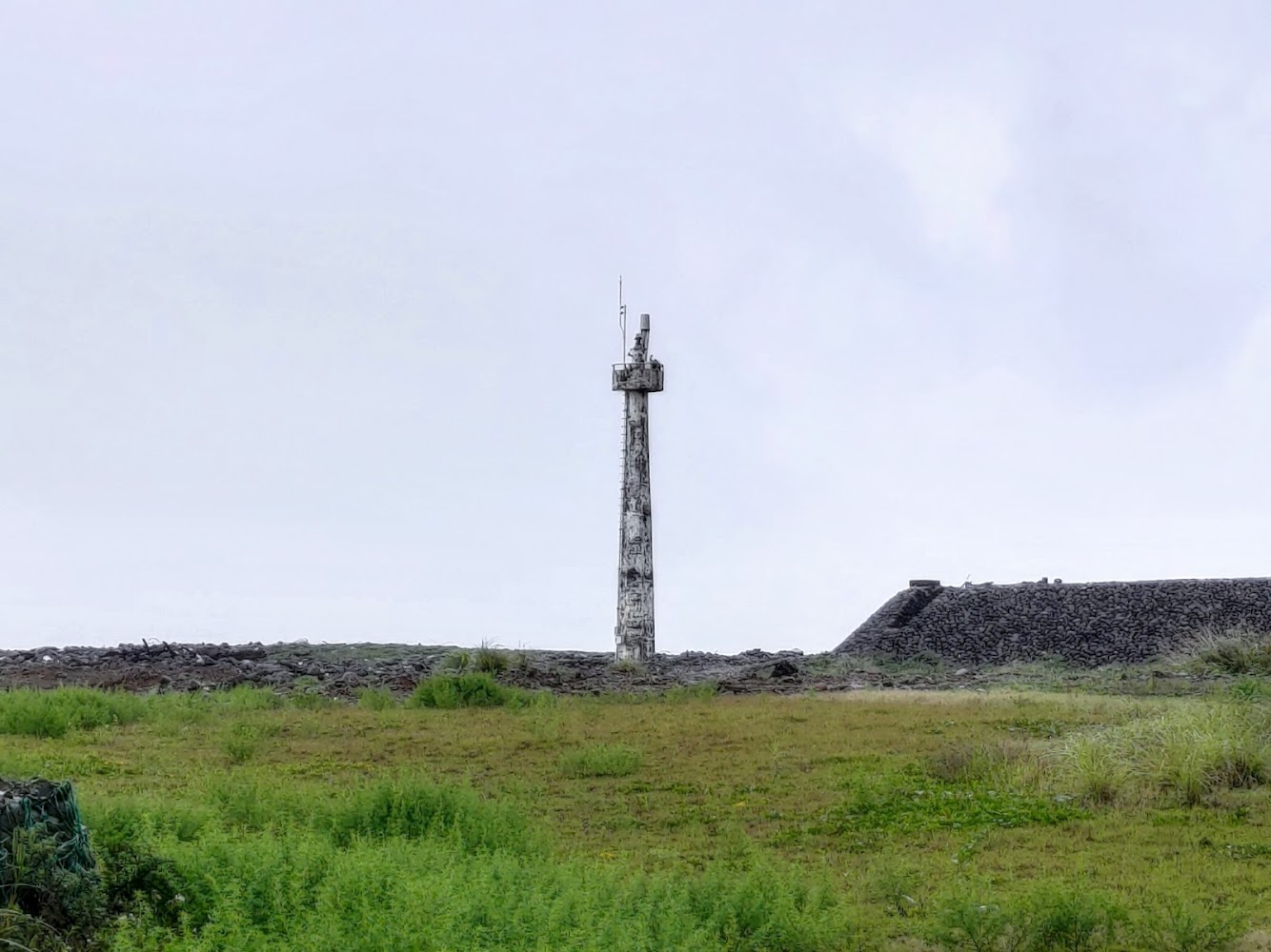 綠地與石地間高聳的混凝土柱地標