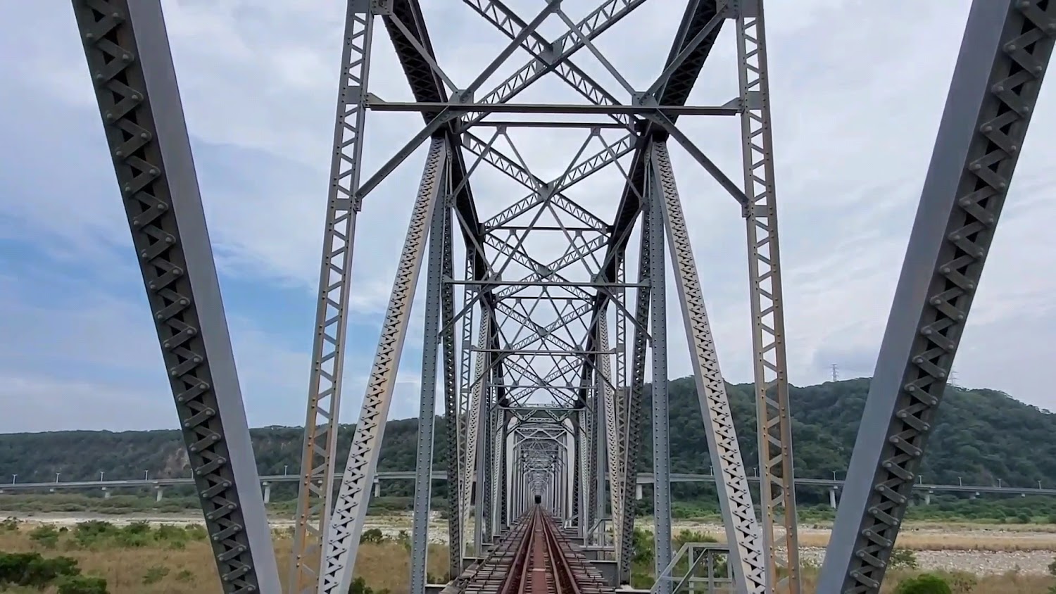 橋上鐵軌與鋼構密集對稱景象