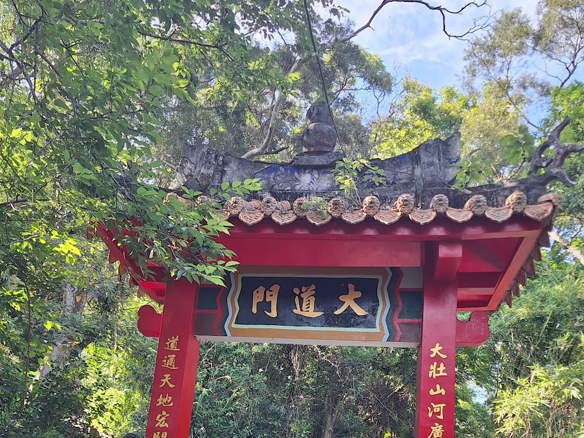 老崎古道入口大道門紅色牌坊金字楹聯綠樹環繞