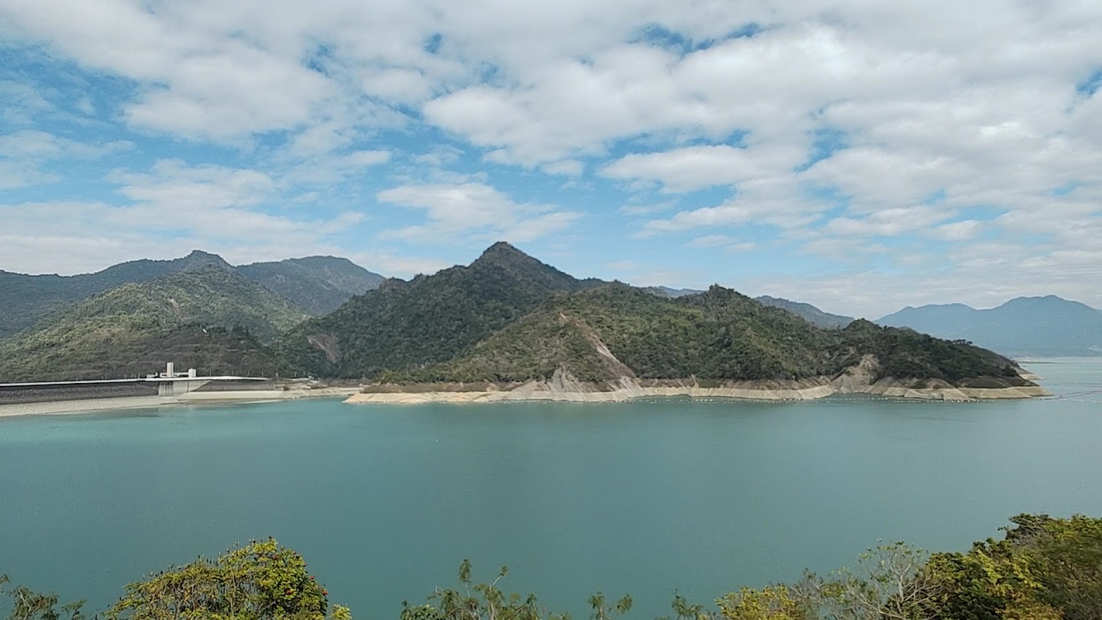 曾文水庫廣角全景,大壩在左側,碧藍水面延伸至群山間